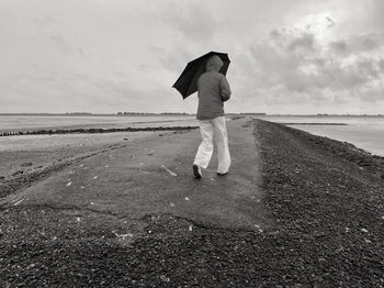 Full length rear view of man standing on beach