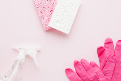 High angle view of hand holding pink over white background