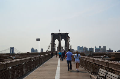 People walking on brooklyn bridge against sky