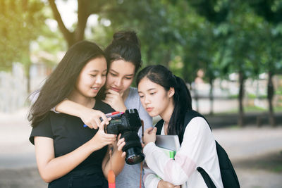 Young women looking at camera while standing outdoors