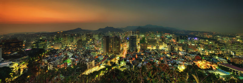 High angle view of illuminated buildings against sky at night