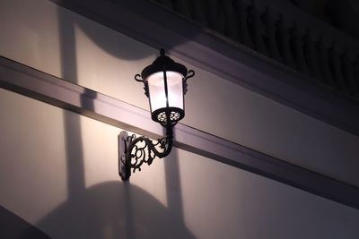 Low angle view of illuminated wall sconce at home