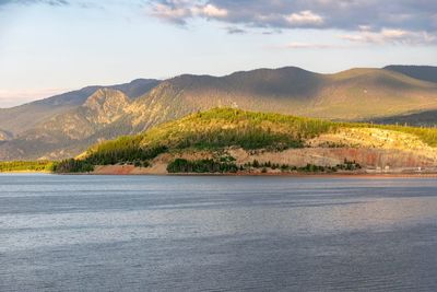 Scenic view of land and mountains against sky