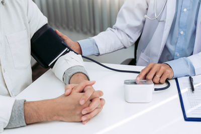 Midsection of man using laptop on table