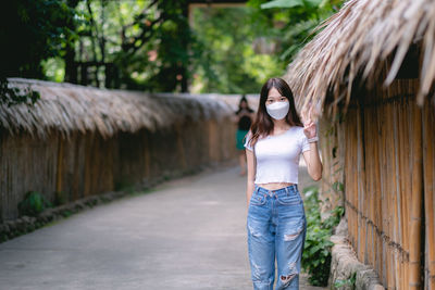 Young woman standing against trees