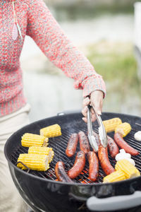 Midsection of woman barbecuing outdoors