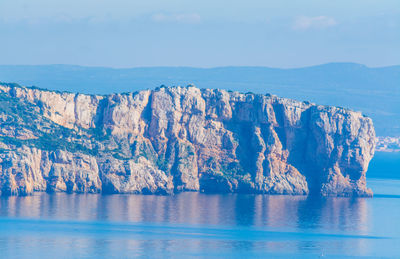 Panoramic shot of sea by mountain against sky