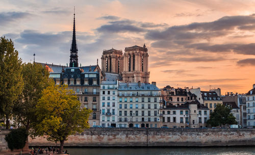 Buildings in city against cloudy sky