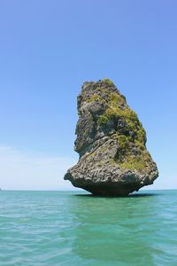 Fantastic boulder standing out from calm turquoise sea