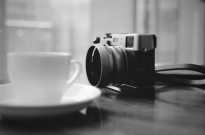 Digital camera with coffee cup on table