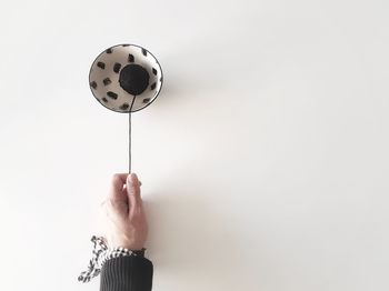 Cropped hand of person holding wool in bowl on table