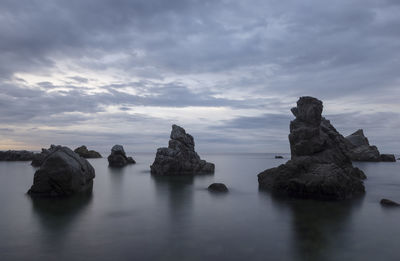 Rocks in sea against sky