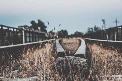 Railroad tracks by bridge against sky