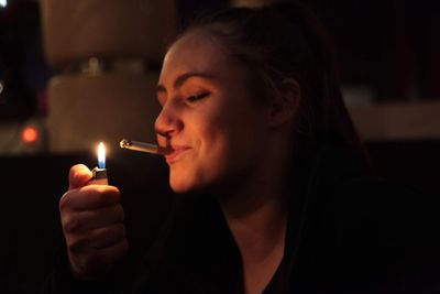 Close-up of woman igniting cigarette