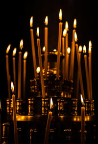 Lit candles in temple against building