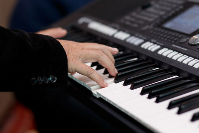 Cropped hands of person playing piano