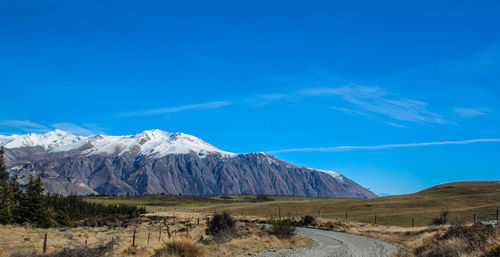 Scenic view of snowcapped mountains against blue sky