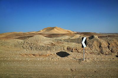 Scenic view of desert against clear blue sky