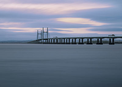Prince of wales bridge over sea against sky during sunset
