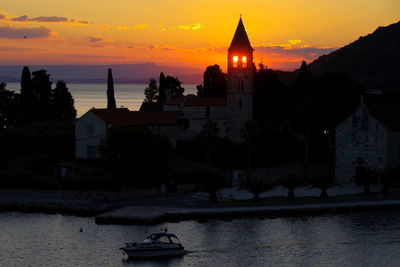 Silhouette buildings against sky during sunset