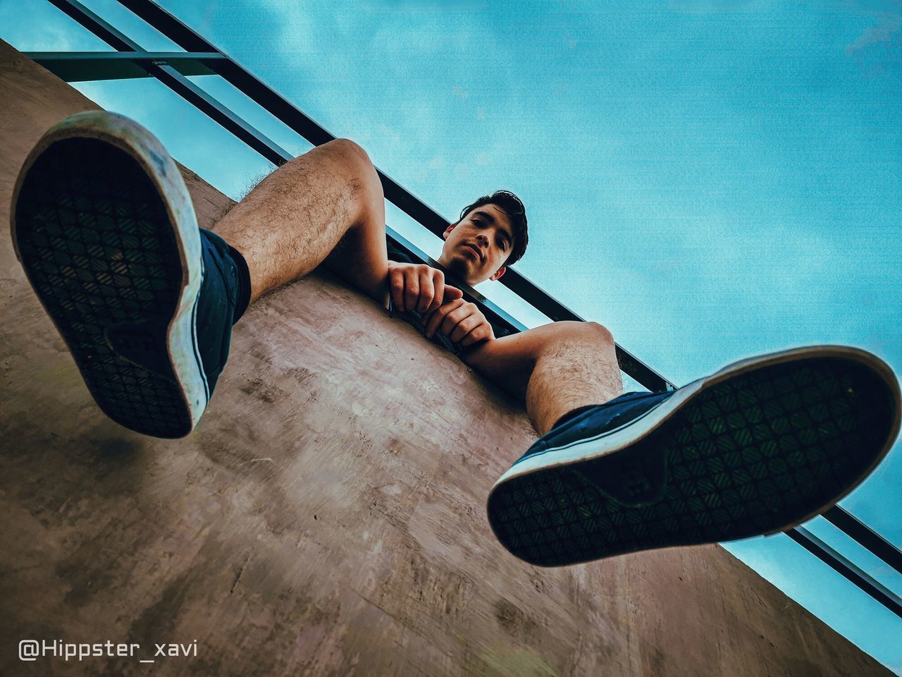 LOW ANGLE VIEW OF YOUNG MAN RELAXING ON SEAT