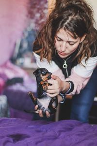 Portrait of young woman with dog sitting outdoors