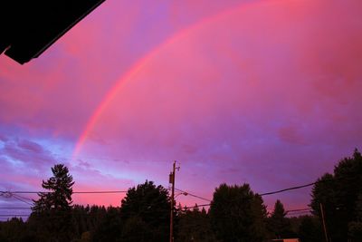 Low angle view of rainbow against sky at sunset