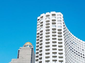 Low angle view of modern building against clear blue sky