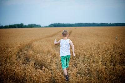 Rear view of boy on field