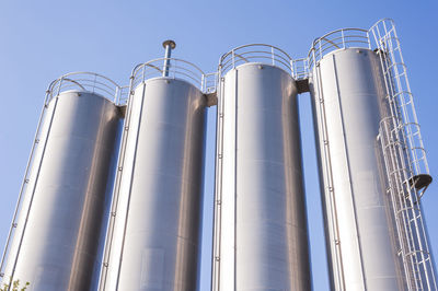 Low angle view of silos against clear sky