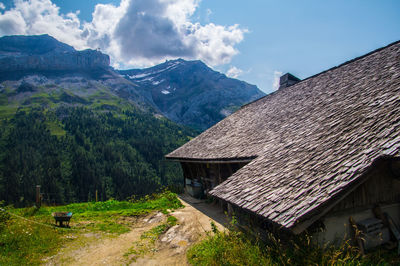 Scenic view of house and mountains against sky