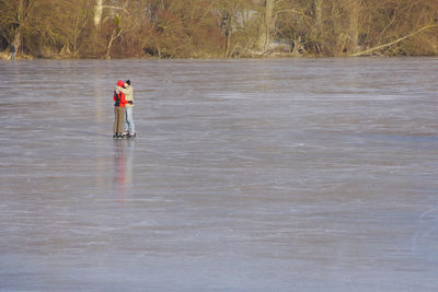 Rear view of man standing in water