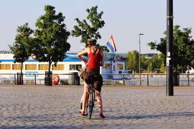Rear view of woman with french flag on bicycle at street