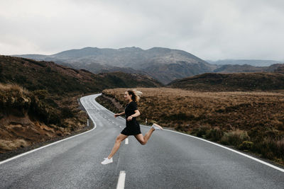 Full length of woman on road against mountain range