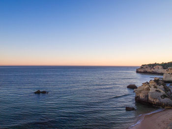 Scenic view of sea against clear sky at sunset