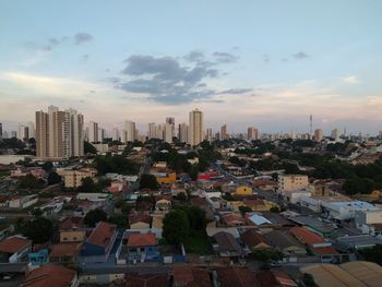 Aerial view of buildings in city against sky during sunset