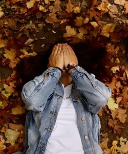 Person standing on maple leaves during autumn