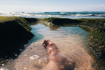 Low section of person relaxing on beach