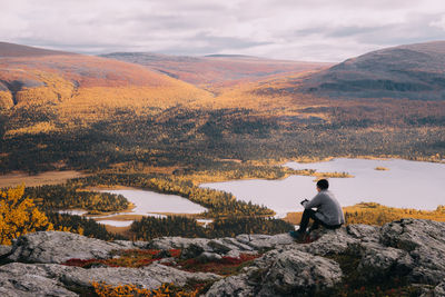 Man looking at lake against mountain range