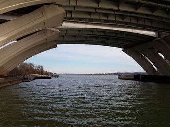 Arch bridge over river against sky