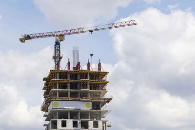 Low angle view of crane against sky