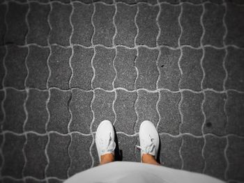 Low section of man standing on cobblestone