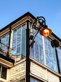 Low angle view of illuminated street light against building