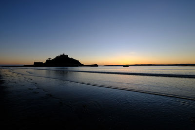 Scenic view of sea against clear sky at sunset