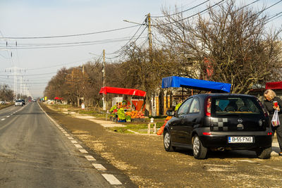 Cars on street in city against sky