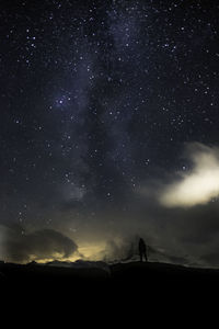 Silhouette of person against star field at night