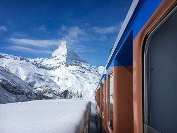 Snow covered mountains against blue sky