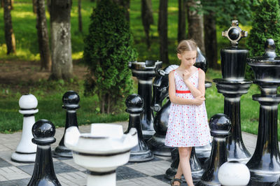 Girl standing on artificial chess board