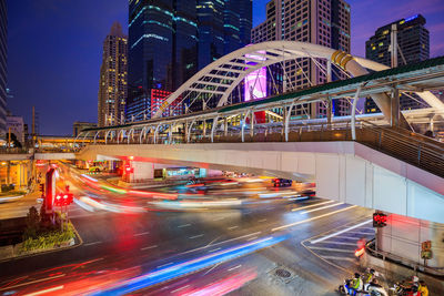 Light trails on city street by buildings at night