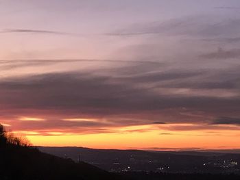 Scenic view of dramatic sky over silhouette landscape